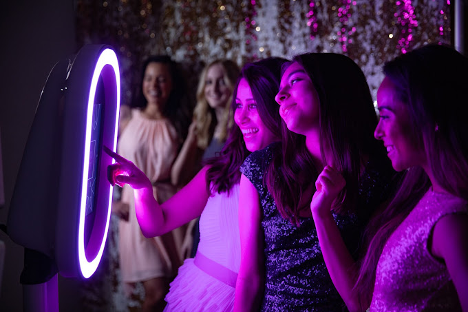 A group of young women standing around a mirror